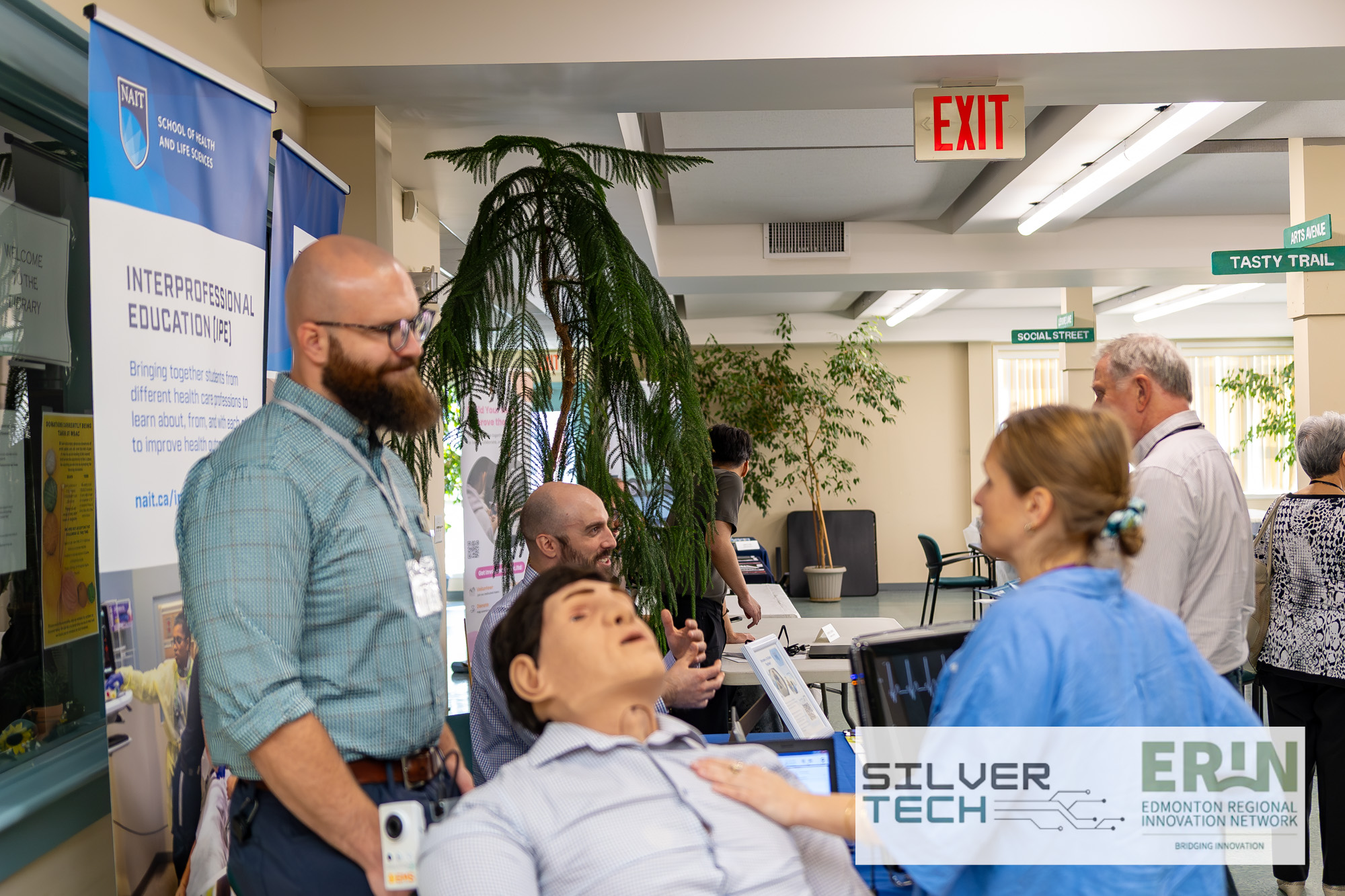 NAIT Interprofessional Education booth with a medical simulation manikin