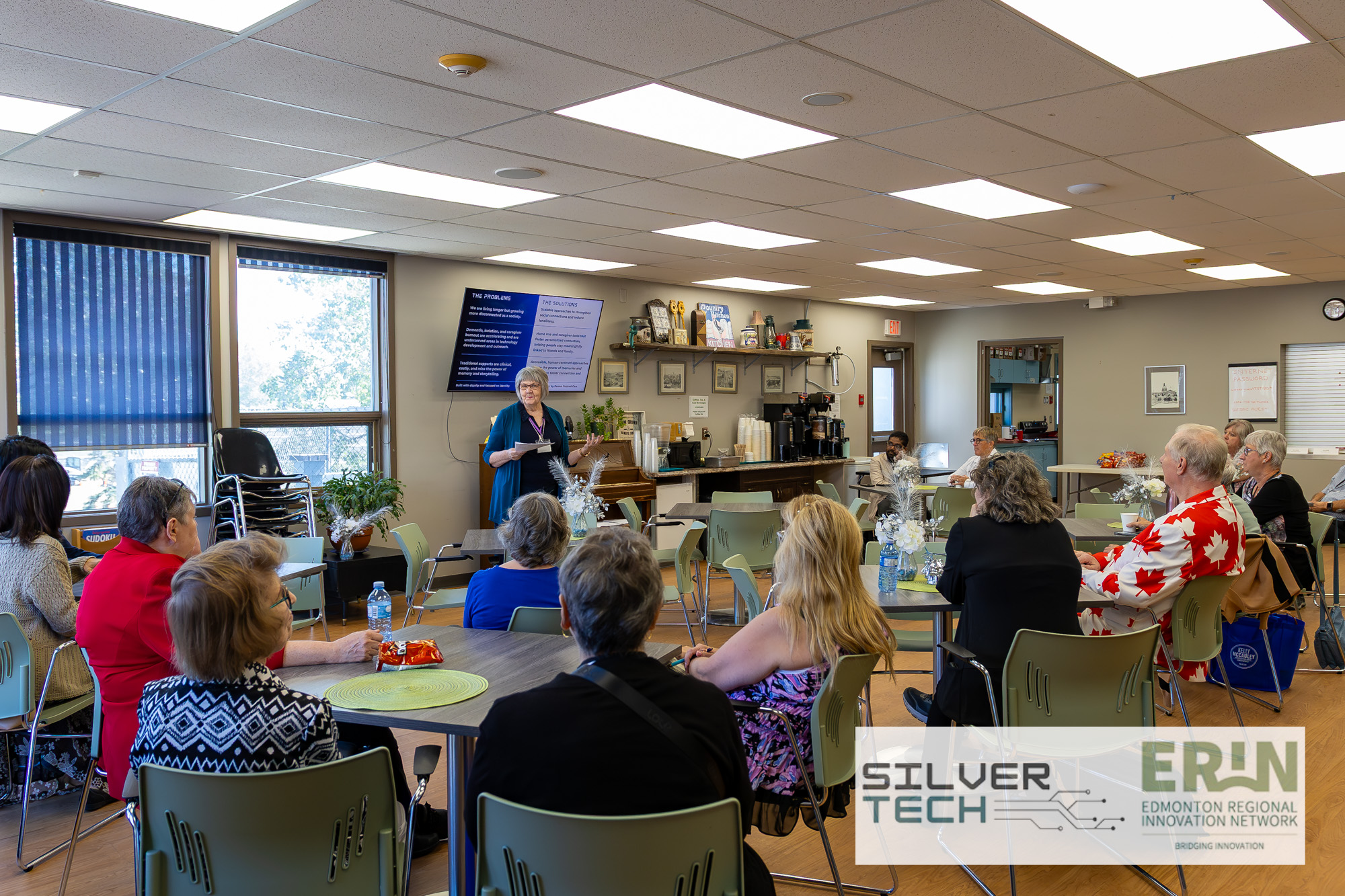 Speaker presenting to seated attendees in a community room at the SilverTech Summit